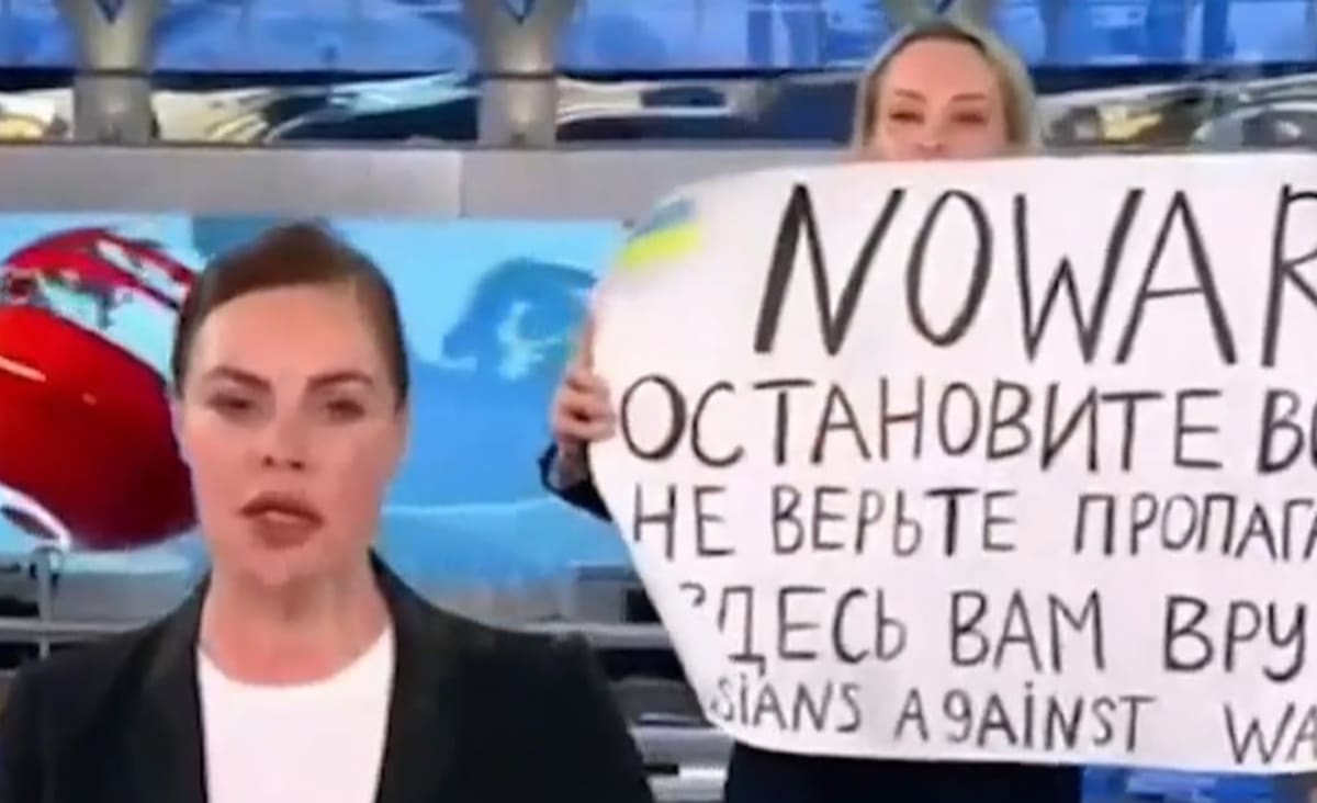 Protester with 'No War' sign walks onto Russian state TV set 